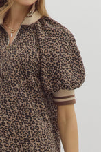 Leopard pattern short puff sleeve half-zip top featuring multicolor band collar. Unlined. Woven. Non-sheer. Lightweight.