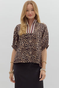 Leopard print high neck elasticated sleeve band dolman top featuring accented multicolor rib band split neck. Unlined. Woven. Non-sheer. Lightweight.