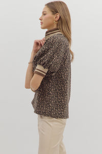 Leopard pattern short puff sleeve half-zip top featuring multicolor band collar. Unlined. Woven. Non-sheer. Lightweight.