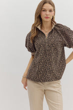 Leopard pattern short puff sleeve half-zip top featuring multicolor band collar. Unlined. Woven. Non-sheer. Lightweight.