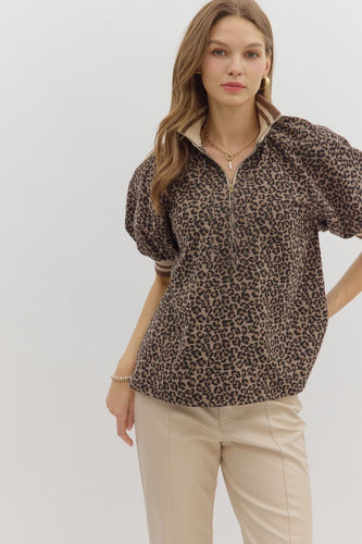 Leopard pattern short puff sleeve half-zip top featuring multicolor band collar. Unlined. Woven. Non-sheer. Lightweight.