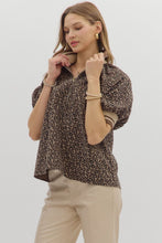 Leopard pattern short puff sleeve half-zip top featuring multicolor band collar. Unlined. Woven. Non-sheer. Lightweight.