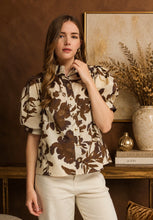 Brown Printed short puff sleeve top featuring button closure at front. Stand neck. Button cuffs. Unlined. Woven. Non-sheer. Lightweight.
