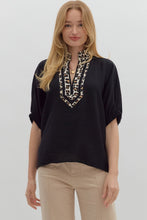 Black Solid elasticated sleeve band dolman top featuring leopard print accented caftan-inspired split neck placket. Unlined. Woven. Non-sheer. Lightweight.