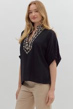 Black Solid elasticated sleeve band dolman top featuring leopard print accented caftan-inspired split neck placket. Unlined. Woven. Non-sheer. Lightweight.