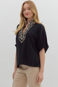 Black Solid elasticated sleeve band dolman top featuring leopard print accented caftan-inspired split neck placket. Unlined. Woven. Non-sheer. Lightweight.