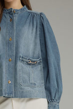 Denim Solid long puff sleeve  with button closure at front. Front patch pockets with metal hardware detail. Button cuffs. Medium weight. Jacket