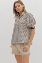 Black Stripe pattern half-zip closure short puff sleeve top featuring multicolor accent band. Unlined. Woven. Non-sheer. Lightweight.