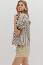 Black Stripe pattern half-zip closure short puff sleeve top featuring multicolor accent band. Unlined. Woven. Non-sheer. Lightweight.