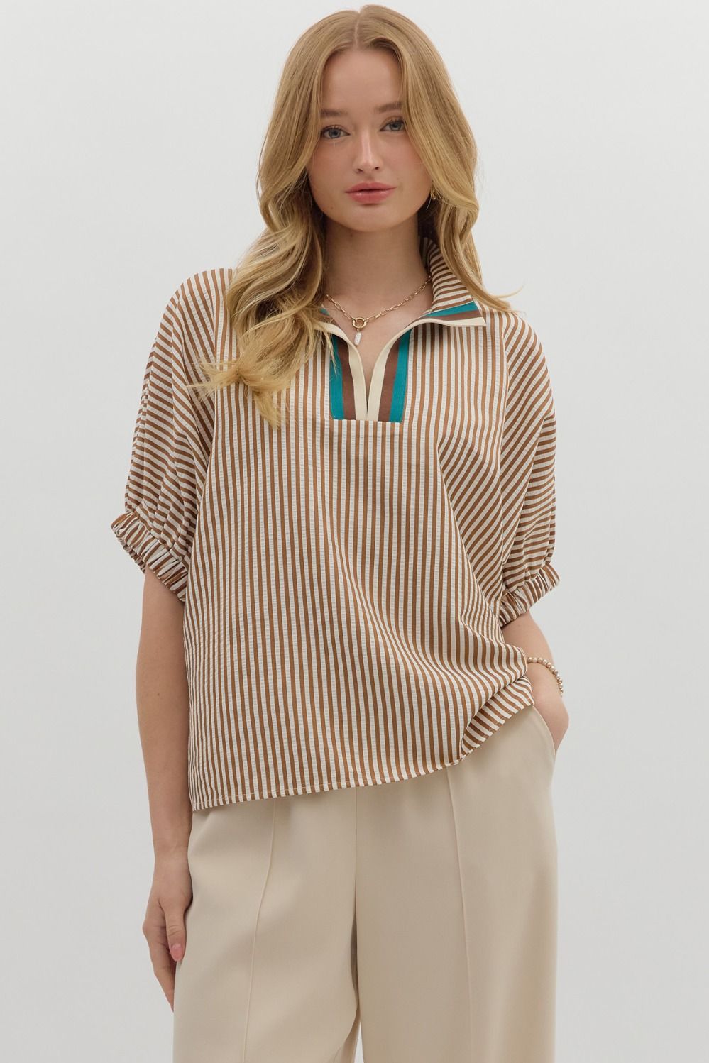 Caramel Stripe pattern high neck elasticated sleeve band dolman top featuring accented multicolor rib band split neck. Unlined. Woven. Non-sheer. Lightweight.