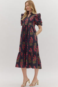 Black Floral print short puff sleeve midi dress featuring elasticized ruffle cuffs, ruffled trim split neckline, and shoulder ruffle accents. Ruffle hem. Side pockets. Lined. Woven. Non-sheer. Lightweight.