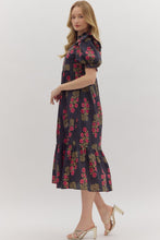 Black Floral print short puff sleeve midi dress featuring elasticized ruffle cuffs, ruffled trim split neckline, and shoulder ruffle accents. Ruffle hem. Side pockets. Lined. Woven. Non-sheer. Lightweight.