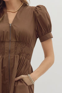 Brown Solid short puff sleeve V-neck mini dress featuring smocked waist front-zip closure. Pockets at sides. Lined. Woven. Non-sheer. Lightweight.