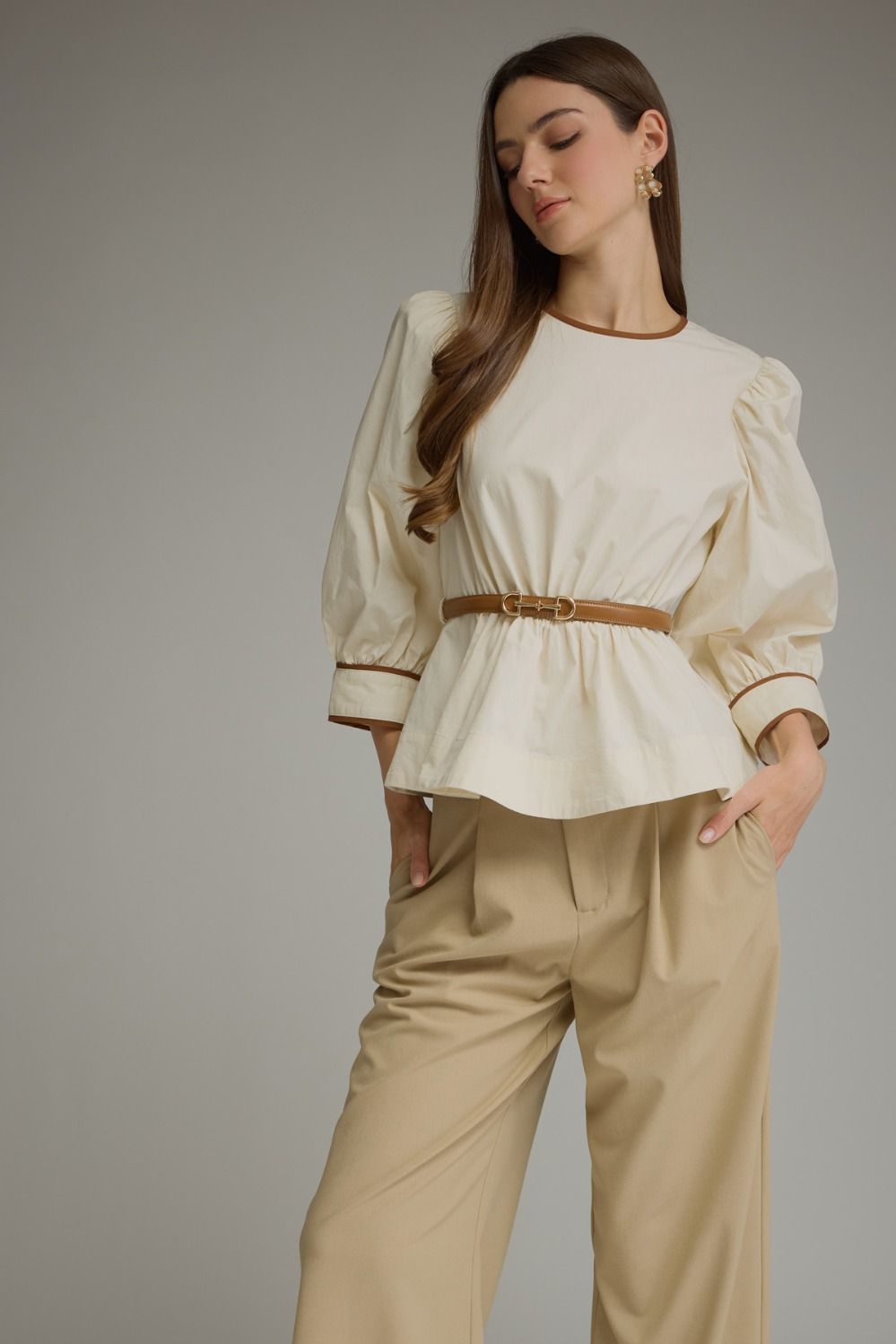 Solid long sleeve top with puff sleeves and contrast trim. Detachable belt included-ivory