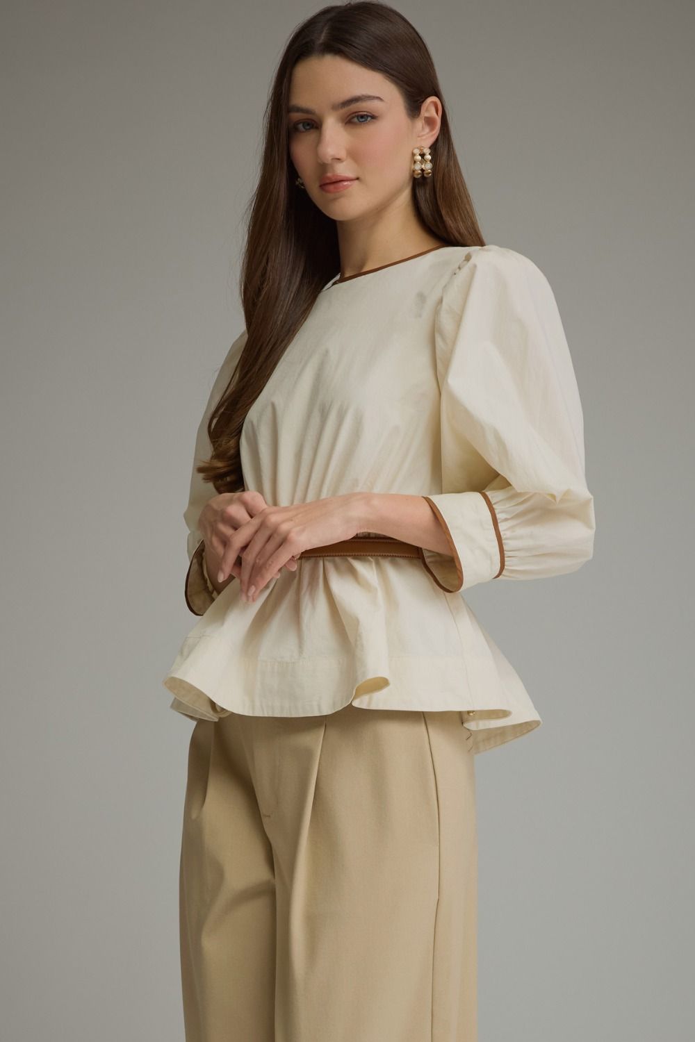 Solid long sleeve top with puff sleeves and contrast trim. Detachable belt included-ivory
